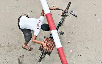 自転車に卵を運んでいる若者が交差点を横断しようとしている