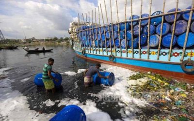 空のプラスチックドラムを洗う労働者