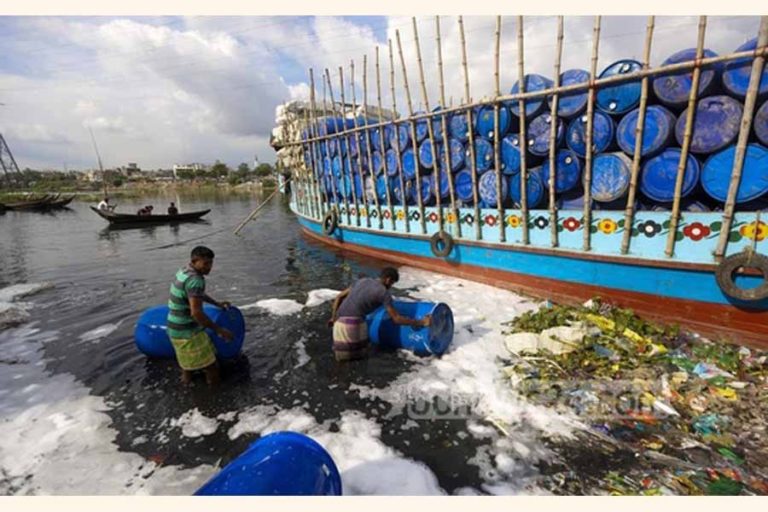 空のプラスチックドラムを洗う労働者