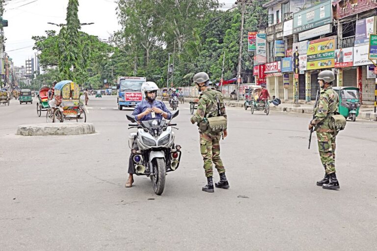 陸軍兵士がバイクの運転手を身体検査する