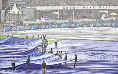 雨で試合が中断されたためグラウンドキーパーがフィールドをカバー