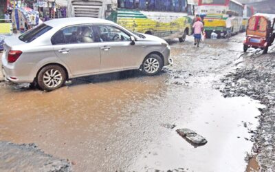 ジャトラバリ交差点で水浸しの幹線道路を横断する車両と歩行者