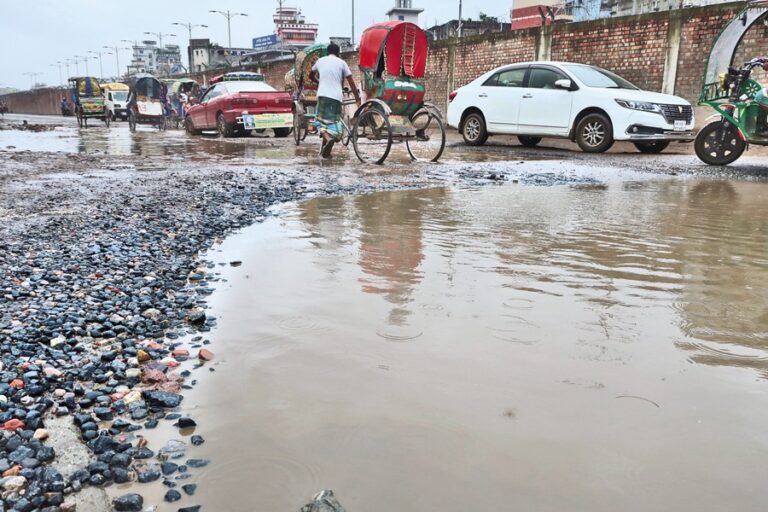 ジャトラバリの水浸しのミール・ハジルバグ新道路を走行する車両
