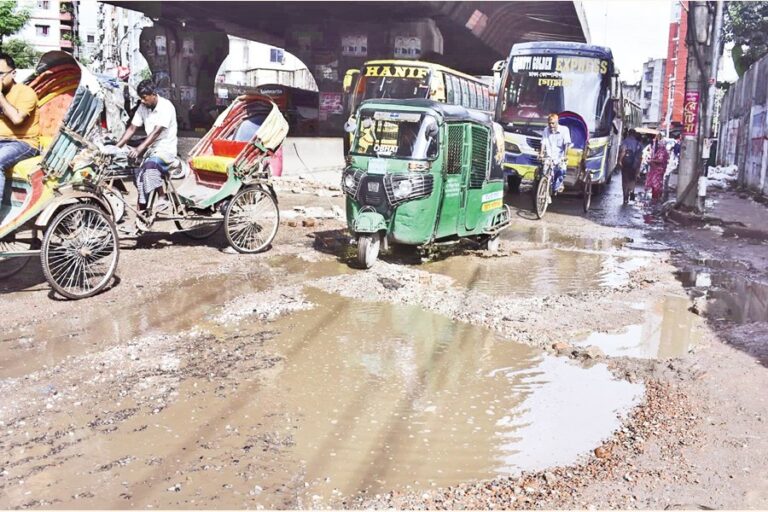 交通量の多い幹線道路の水浸しの穴の中を走る車