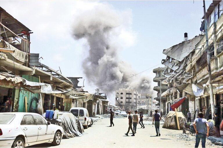 イスラエルのガザ攻撃で煙が上がるのを見つめるパレスチナ人