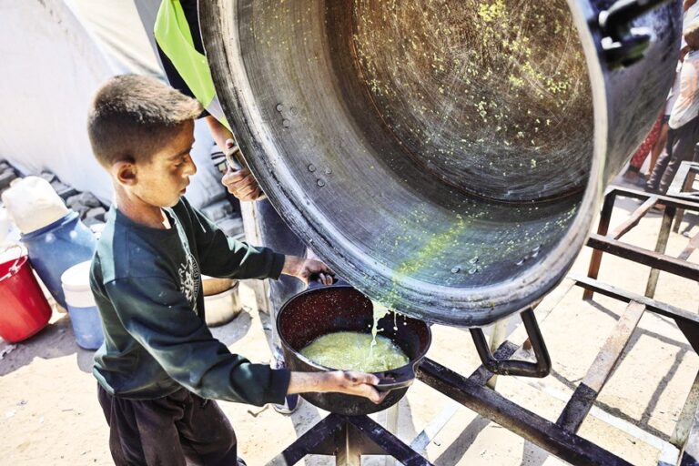 パレスチナの少年がレンズ豆のスープの最後の一滴を受け取る