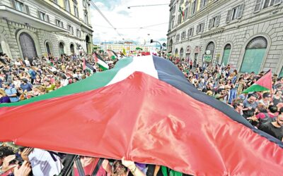 全国規模のストライキ「すべてを阻止しよう」で、巨大なパレスチナ国旗を掲げて行進する人々