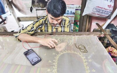 職人がドレスに複雑な縫製デザインを施している