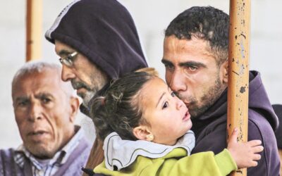 パレスチナ人の弔問客が赤ん坊の娘にキスをしながら涙を流す