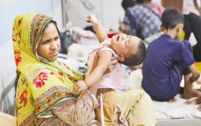 幼い患者が母親の膝の上で痛みに身をよじっている。