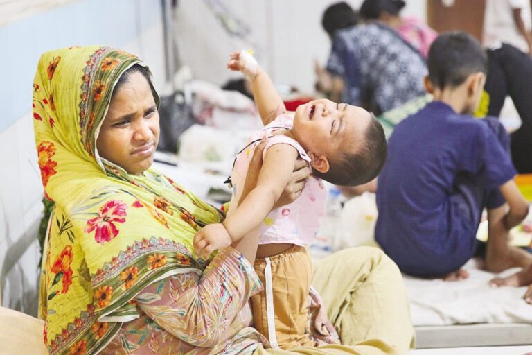 幼い患者が母親の膝の上で痛みに身をよじっている。