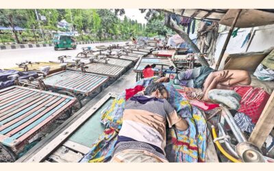 首都のモティジール地区で、人力車の運転手たちが自分の車にもたれかかっている。