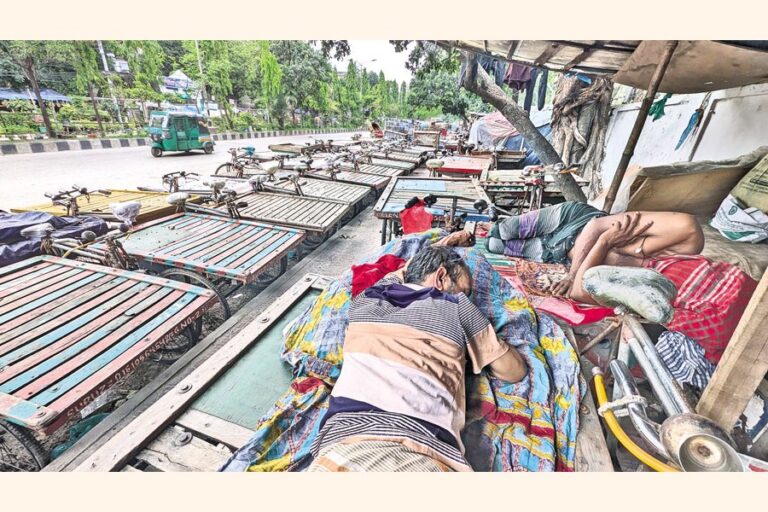 首都のモティジール地区で、人力車の運転手たちが自分の車にもたれかかっている。