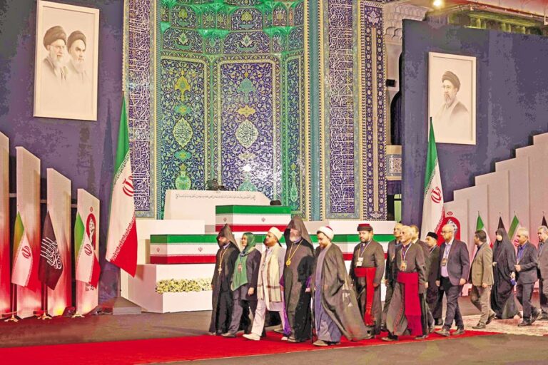 イランの最高指導者アリー・ハメネイ師の棺の前を、地元および外国の当局者が歩いて通り過ぎる。